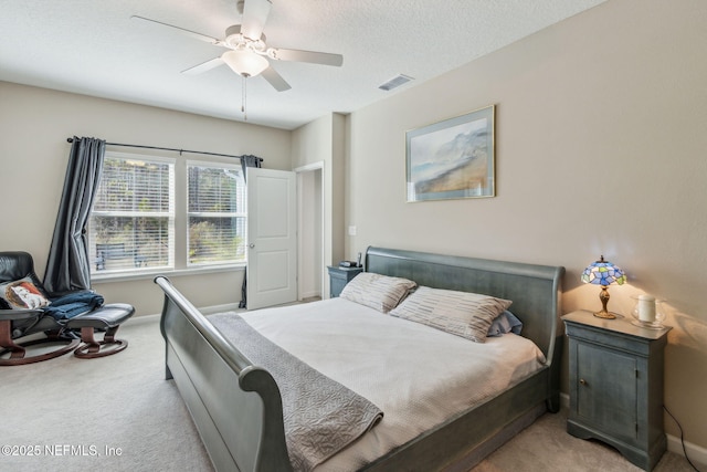 carpeted bedroom featuring a textured ceiling and ceiling fan