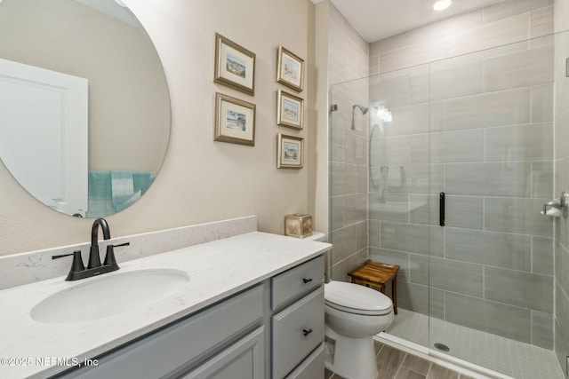 bathroom featuring vanity, toilet, and walk in shower