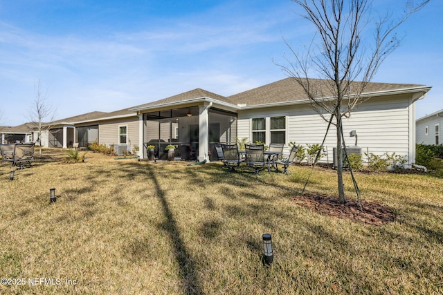 rear view of property with a yard and a sunroom