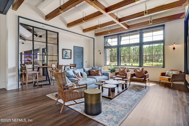 living room featuring hardwood / wood-style flooring, beam ceiling, and a high ceiling