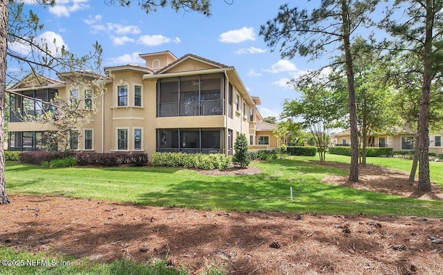 back of property with a sunroom and a yard