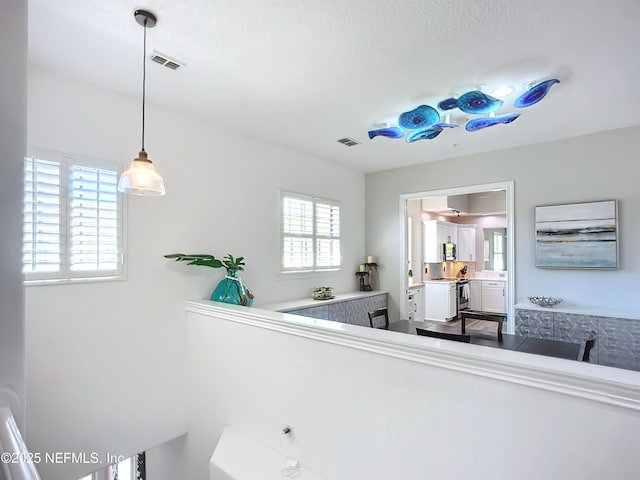 interior space with a healthy amount of sunlight, vanity, and a textured ceiling