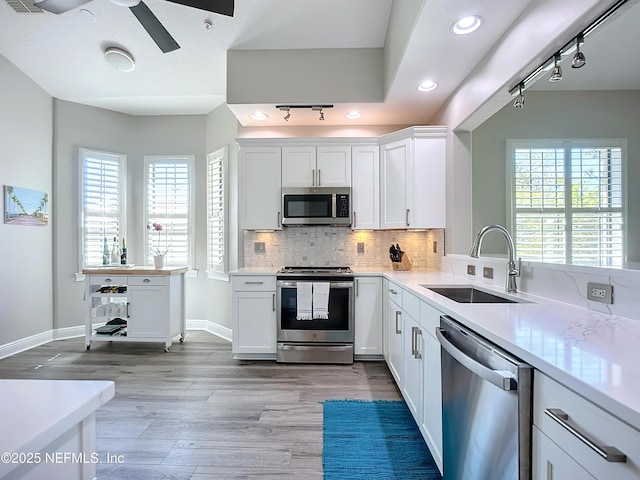 kitchen featuring sink, stainless steel appliances, white cabinets, and ceiling fan