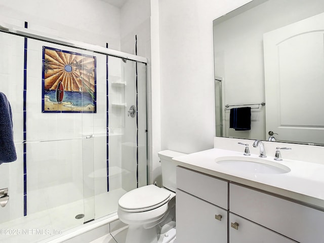 bathroom featuring vanity, toilet, and a shower with door