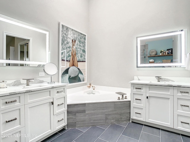 bathroom with a relaxing tiled tub, vanity, and tile patterned flooring