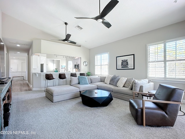 carpeted living room with lofted ceiling and ceiling fan