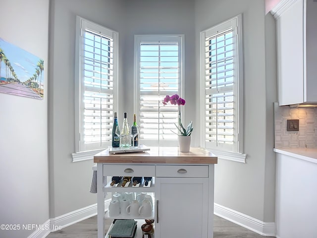 details with wood-type flooring, bar area, and backsplash