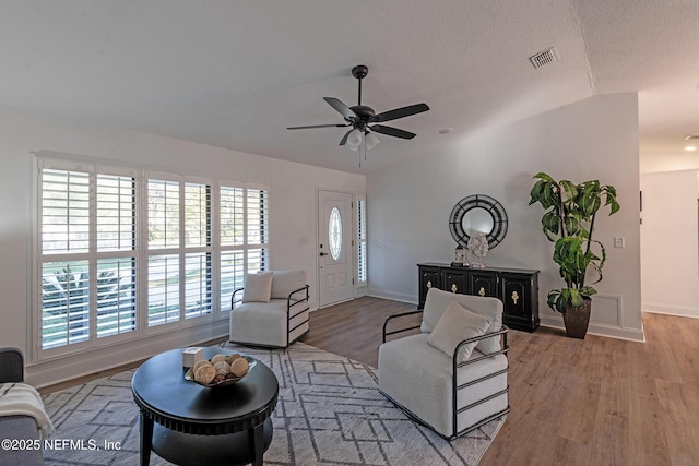 living room featuring hardwood / wood-style floors, ceiling fan, and lofted ceiling