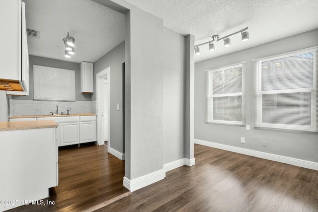 kitchen featuring white cabinetry, sink, a textured ceiling, and dark hardwood / wood-style flooring