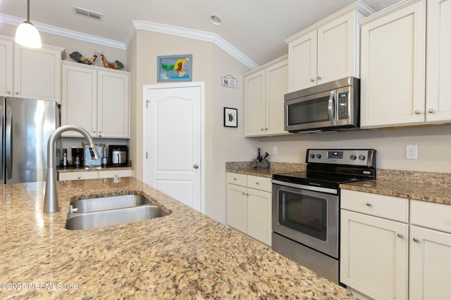 kitchen with white cabinets, crown molding, sink, appliances with stainless steel finishes, and decorative light fixtures