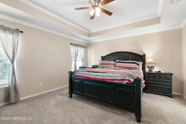 carpeted bedroom with a raised ceiling, ceiling fan, and ornamental molding