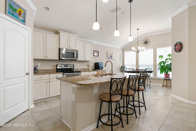 kitchen featuring a center island with sink, white cabinets, pendant lighting, and appliances with stainless steel finishes