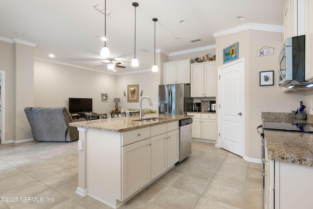 kitchen featuring a center island with sink, sink, hanging light fixtures, ceiling fan, and appliances with stainless steel finishes