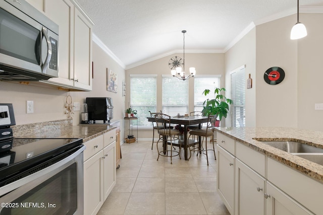 kitchen with white cabinetry, light stone counters, decorative light fixtures, and appliances with stainless steel finishes