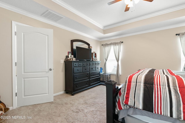 carpeted bedroom with a raised ceiling, ceiling fan, and crown molding