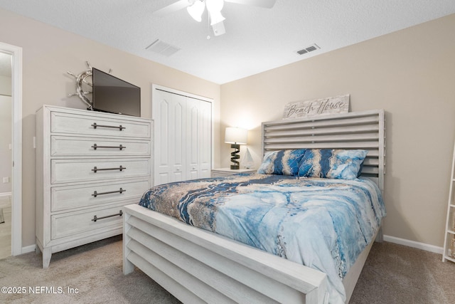 carpeted bedroom featuring ceiling fan, a textured ceiling, and a closet