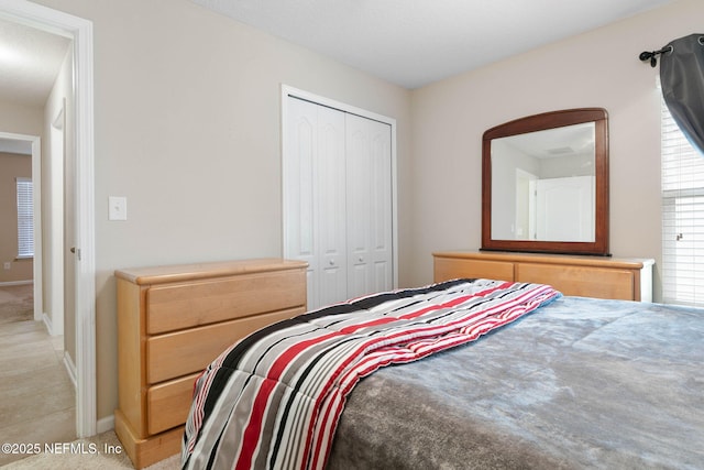 bedroom featuring light colored carpet and a closet