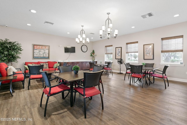 dining space featuring hardwood / wood-style flooring and a chandelier