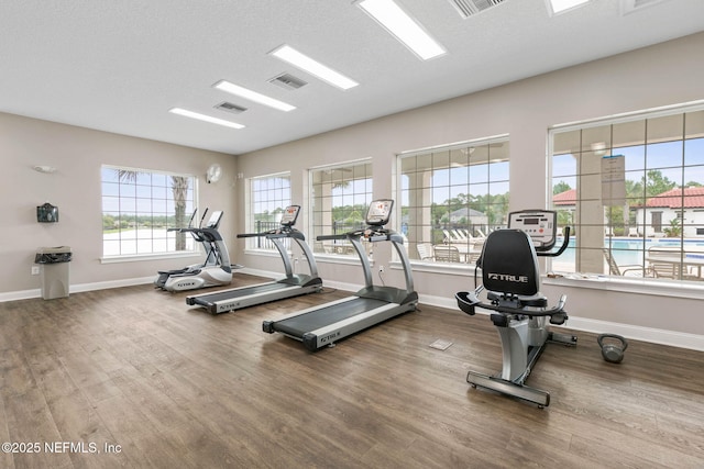 workout area with wood-type flooring and a textured ceiling