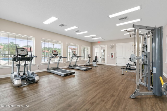 workout area featuring a textured ceiling and dark hardwood / wood-style floors