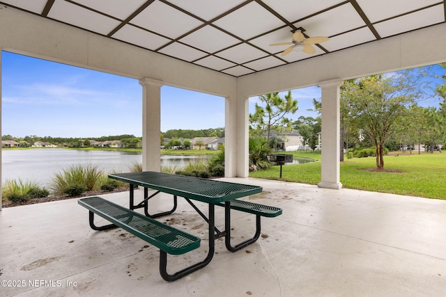 view of patio with ceiling fan and a water view