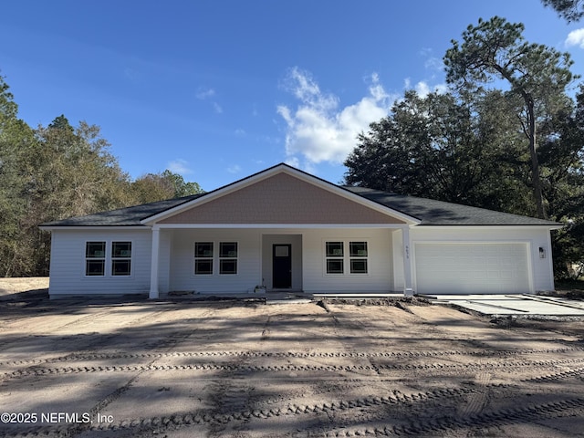 ranch-style home featuring covered porch and a garage