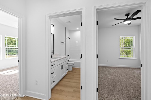 hallway with light carpet and sink