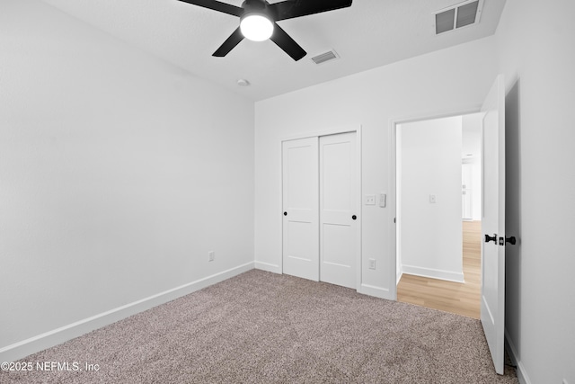 unfurnished bedroom featuring ceiling fan, a closet, and carpet