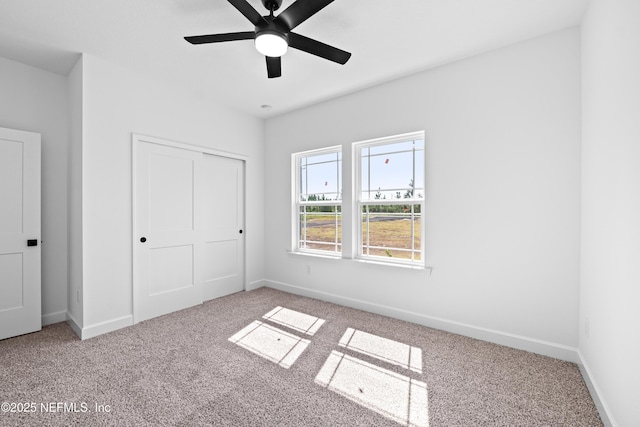 unfurnished bedroom with ceiling fan, carpet floors, and a closet