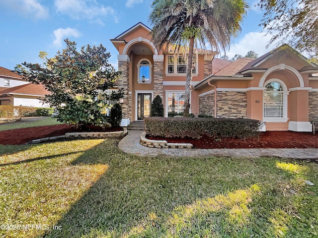 mediterranean / spanish-style home featuring a front yard