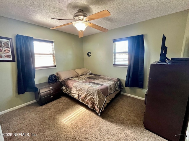 bedroom featuring ceiling fan, carpet floors, a textured ceiling, and multiple windows