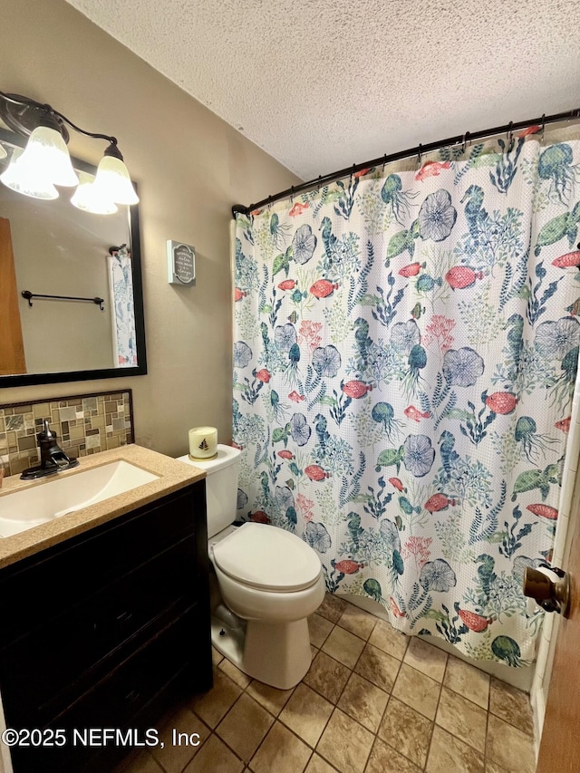 bathroom with a textured ceiling, vanity, toilet, and backsplash