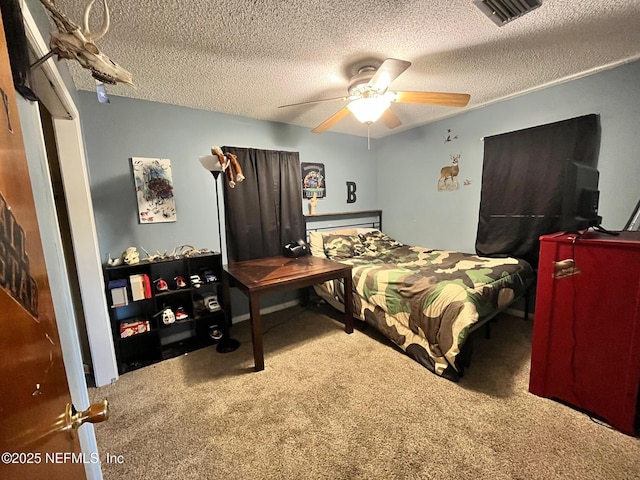 carpeted bedroom featuring a textured ceiling and ceiling fan