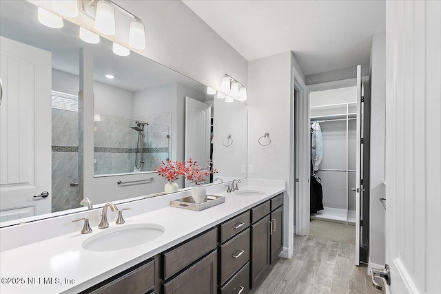 bathroom with vanity, tiled shower, and hardwood / wood-style floors