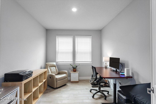 office space featuring a textured ceiling and light wood-type flooring