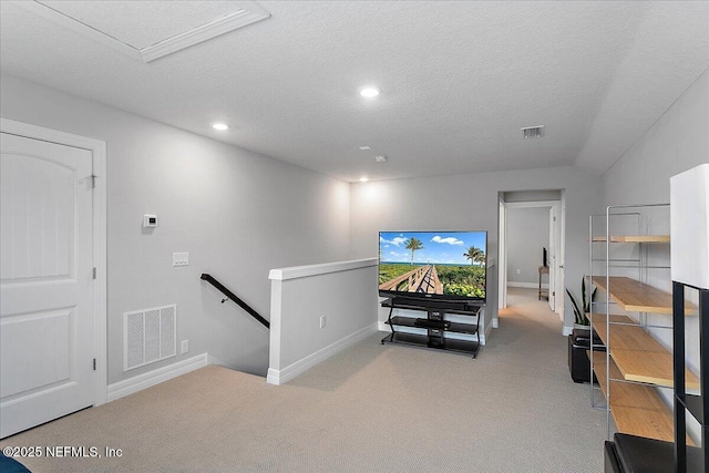 interior space with a textured ceiling and light colored carpet