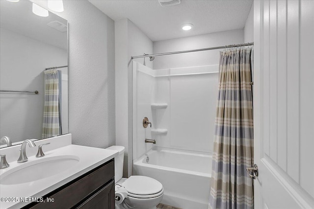 full bathroom featuring toilet, a textured ceiling, shower / bath combo, and vanity