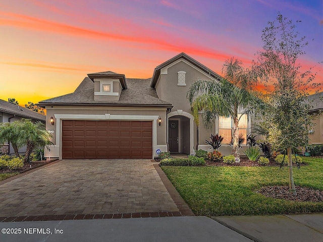 view of front of home with a garage and a lawn