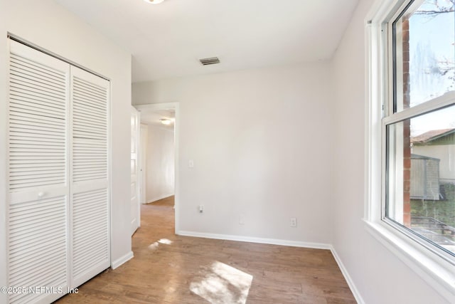 unfurnished bedroom with light hardwood / wood-style floors and a closet