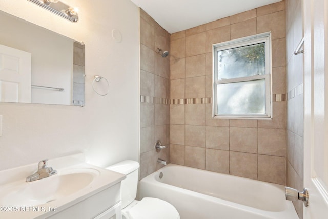 full bathroom featuring toilet, vanity, tiled shower / bath combo, and a healthy amount of sunlight