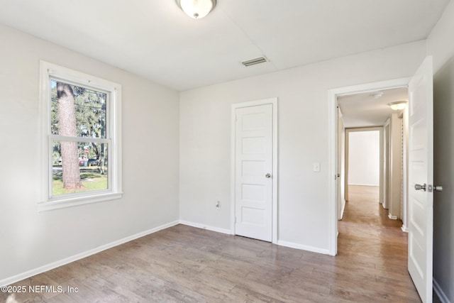 unfurnished bedroom featuring light hardwood / wood-style floors and a closet