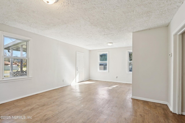 unfurnished room with hardwood / wood-style flooring and a textured ceiling