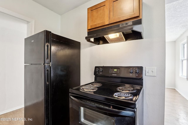 kitchen with a textured ceiling, black appliances, and light wood-type flooring