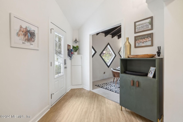 entrance foyer with wood-type flooring and lofted ceiling