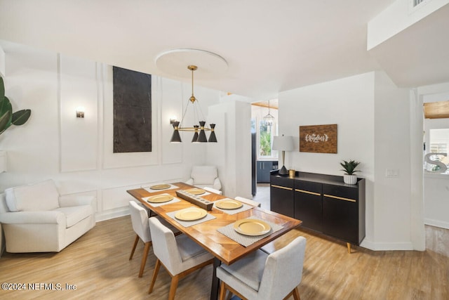 dining room featuring light hardwood / wood-style flooring and a notable chandelier