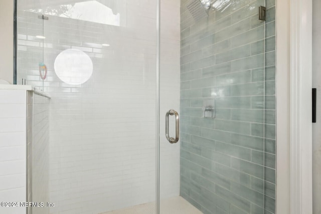 bathroom featuring a shower with door