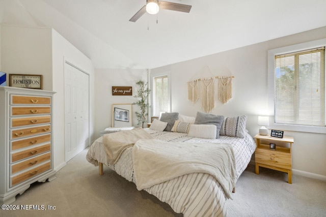 carpeted bedroom featuring a closet, lofted ceiling, and ceiling fan