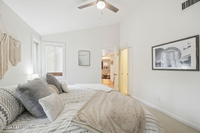 bedroom featuring ceiling fan, light carpet, and vaulted ceiling