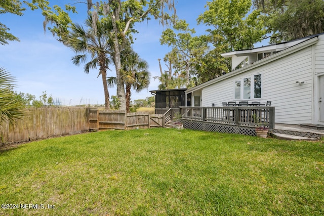 view of yard featuring a sunroom and a deck