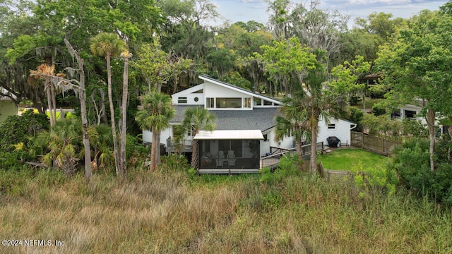 rear view of property featuring a sunroom